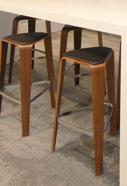 Davis Tre bar stool made of walnut with coffee bean upholsterd seat pad.