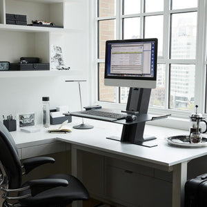 Sit/stand workstation shown with monitor and keyboard