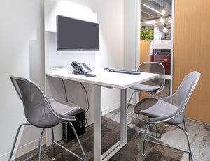 Counter stool upholstered in grey with steel mesh back and aluminum legs with white plastic glides