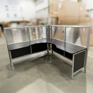 Mobile L-shaped workstation with surrounding semi-clear upper and coloured lower panels. Black worksurface and panels.