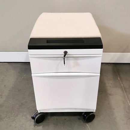 White lockable mobile pedestal with white upholstered seat cushion and black molded handle for easy rolling on four lockable casters.