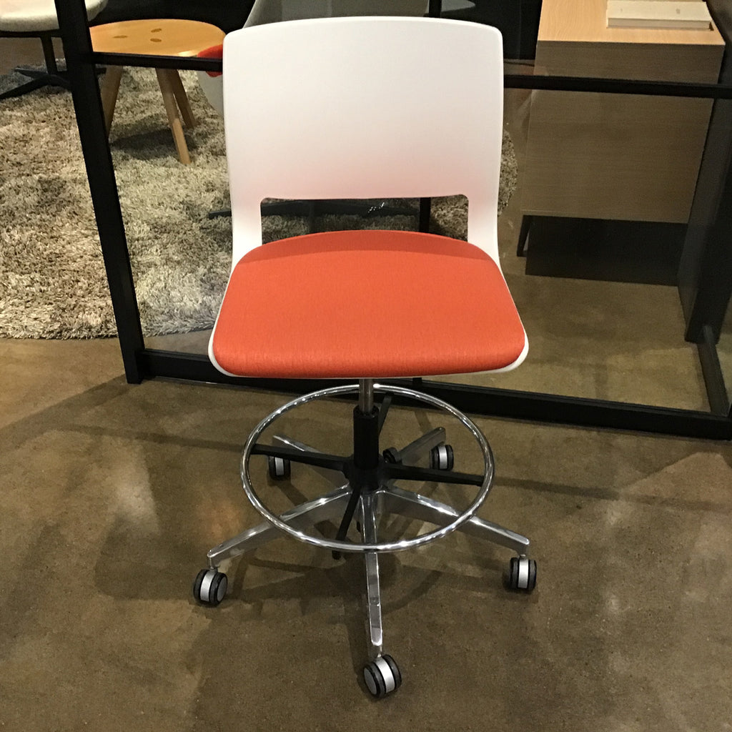 Multi-use swivel stool with white plastic shell and red upholstery. Polished aluminum footrest and frame. 5-star caster base.